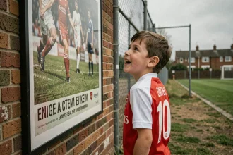 Jeune fan d'Arsenal en maillot numéro 10 admirant un poster vintage de football sur un terrain urbain londonien